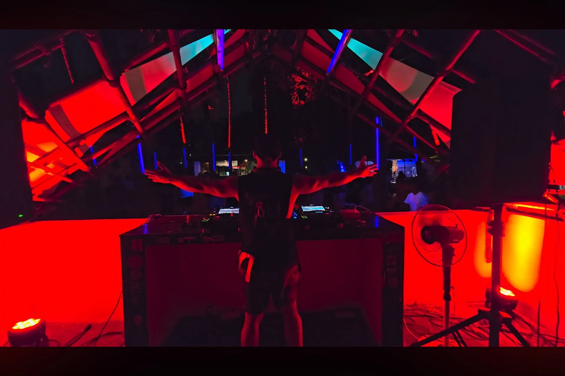 Kevin Em actuando tras los platos bajo luces rojas y azules
